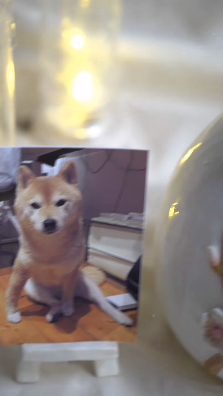 A finished ceramic urn with Baya’s name on it, filmed beside a photo of Baya