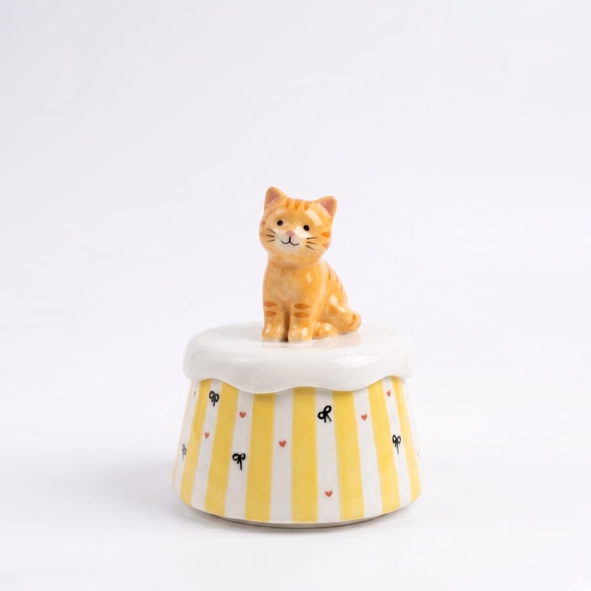 A cream ceramic pet urn on a wooden shelf in a living room