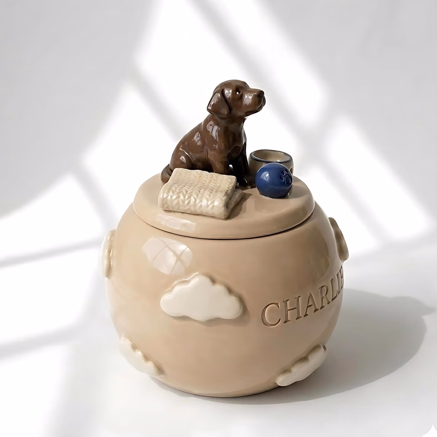 Close-up of the sculpted figurine and engraved name on a ceramic urn