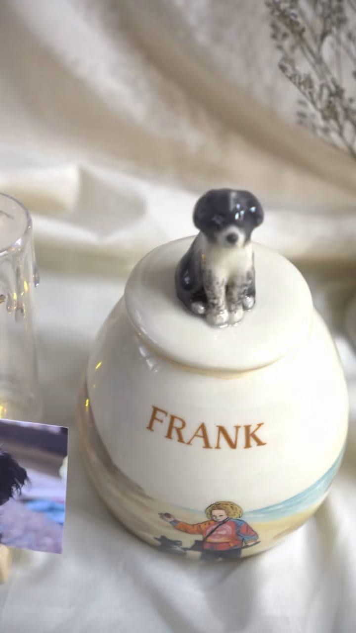 A finished ceramic urn with Frank’s name on it, filmed beside a photo of Frank
