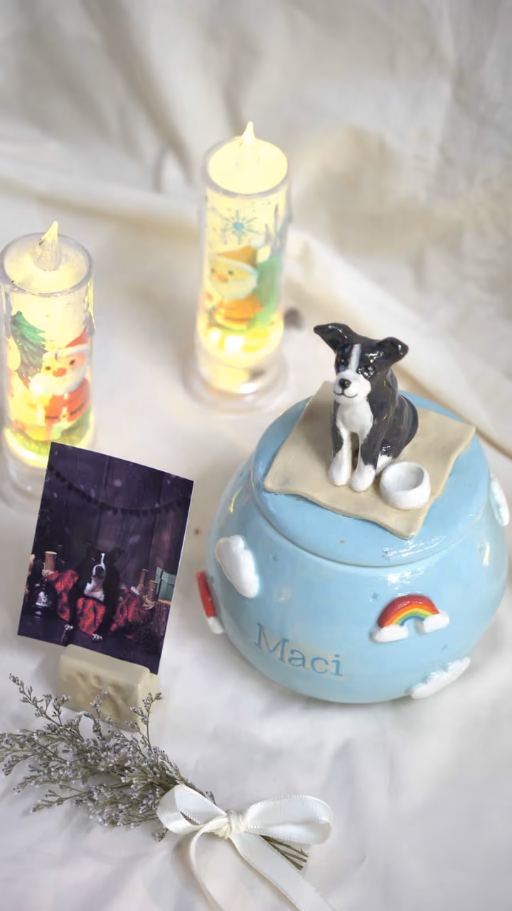 A finished ceramic urn with Maci’s name on it, filmed beside a photo of Maci