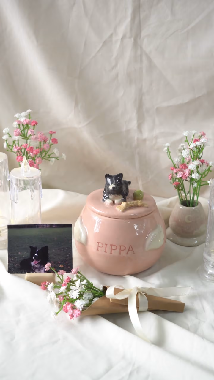 A finished ceramic urn with Pippa’s name on it, filmed beside a photo of Pippa