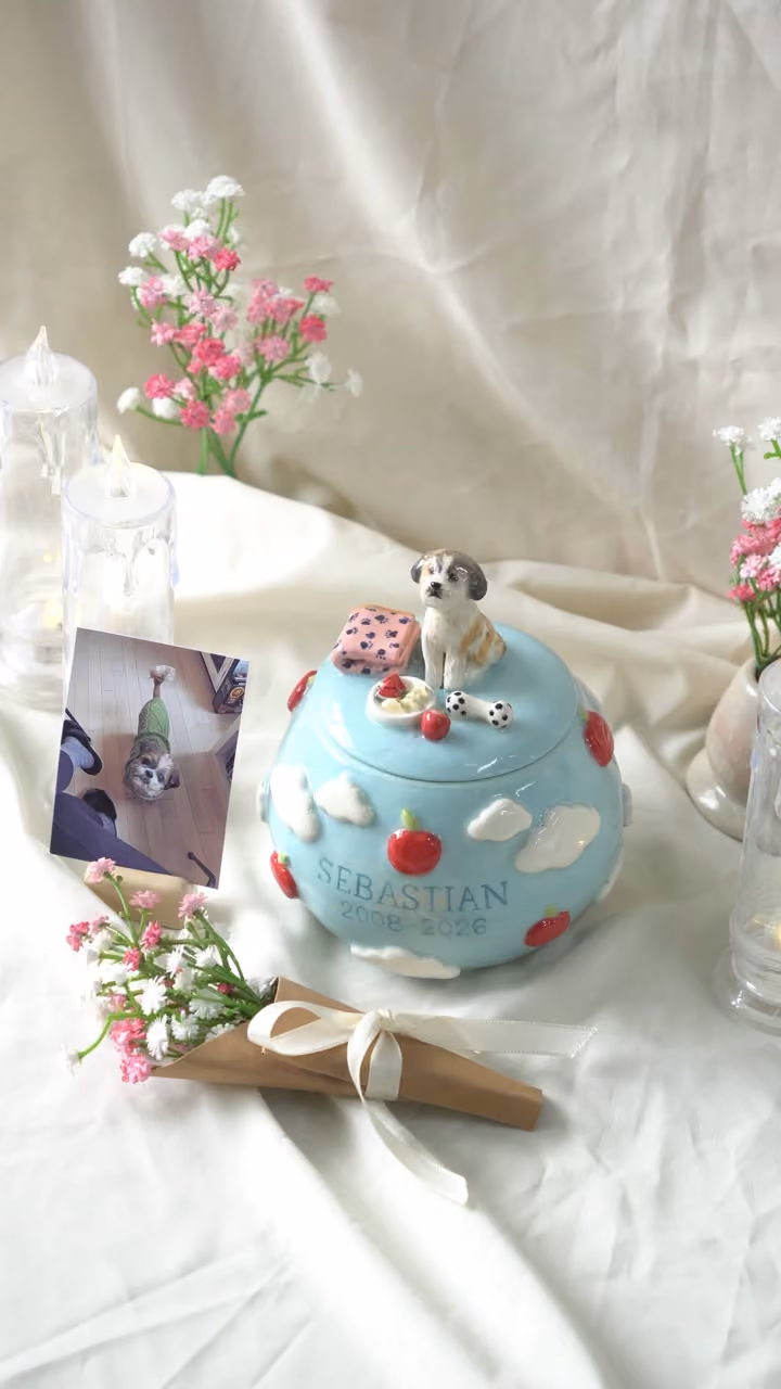 A finished ceramic urn with Sebastian’s name on it, filmed beside a photo of Sebastian