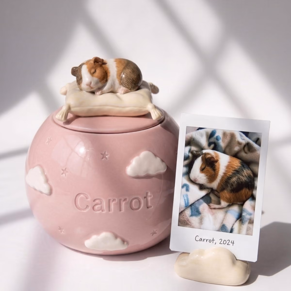 A ceramic pet urn topped with a hand-sculpted figurine of a sleeping dog