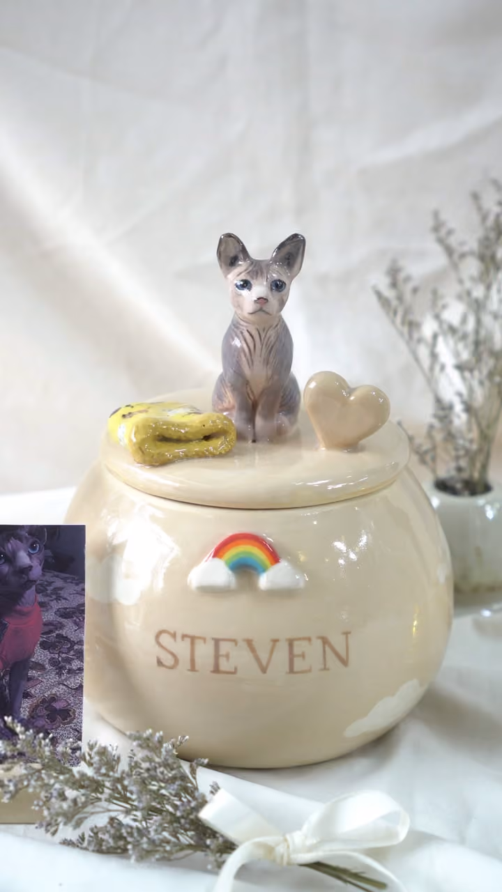 A finished ceramic urn with Steven’s name on it, filmed beside a photo of Steven