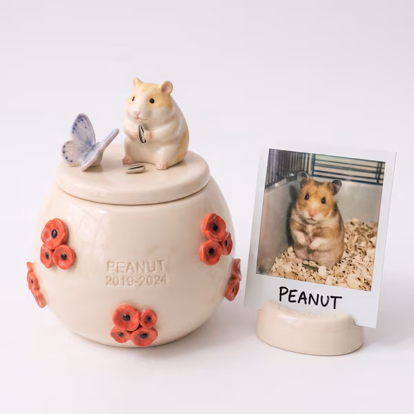 Ceramic corgi memorial urn displayed beside its matching ceramic photo stand